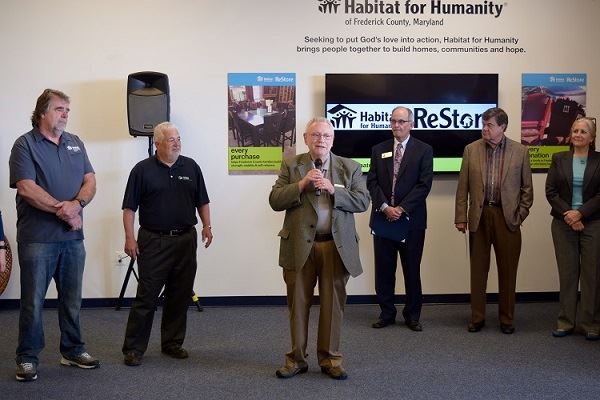 Rev. Ken Dunnington giving an invocation before the ribbon cutting  
