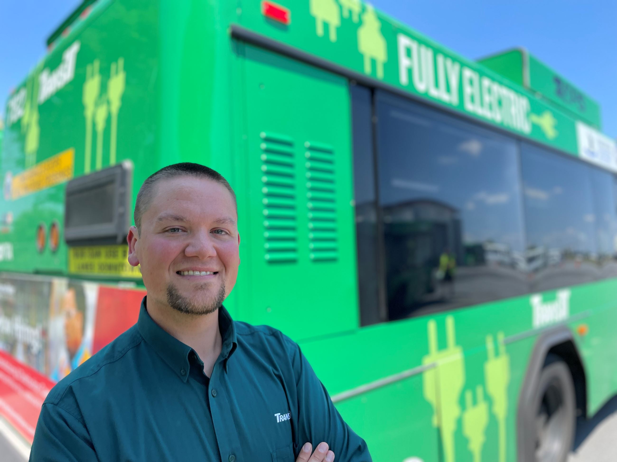 Roman Steichen stands in front of a green bus