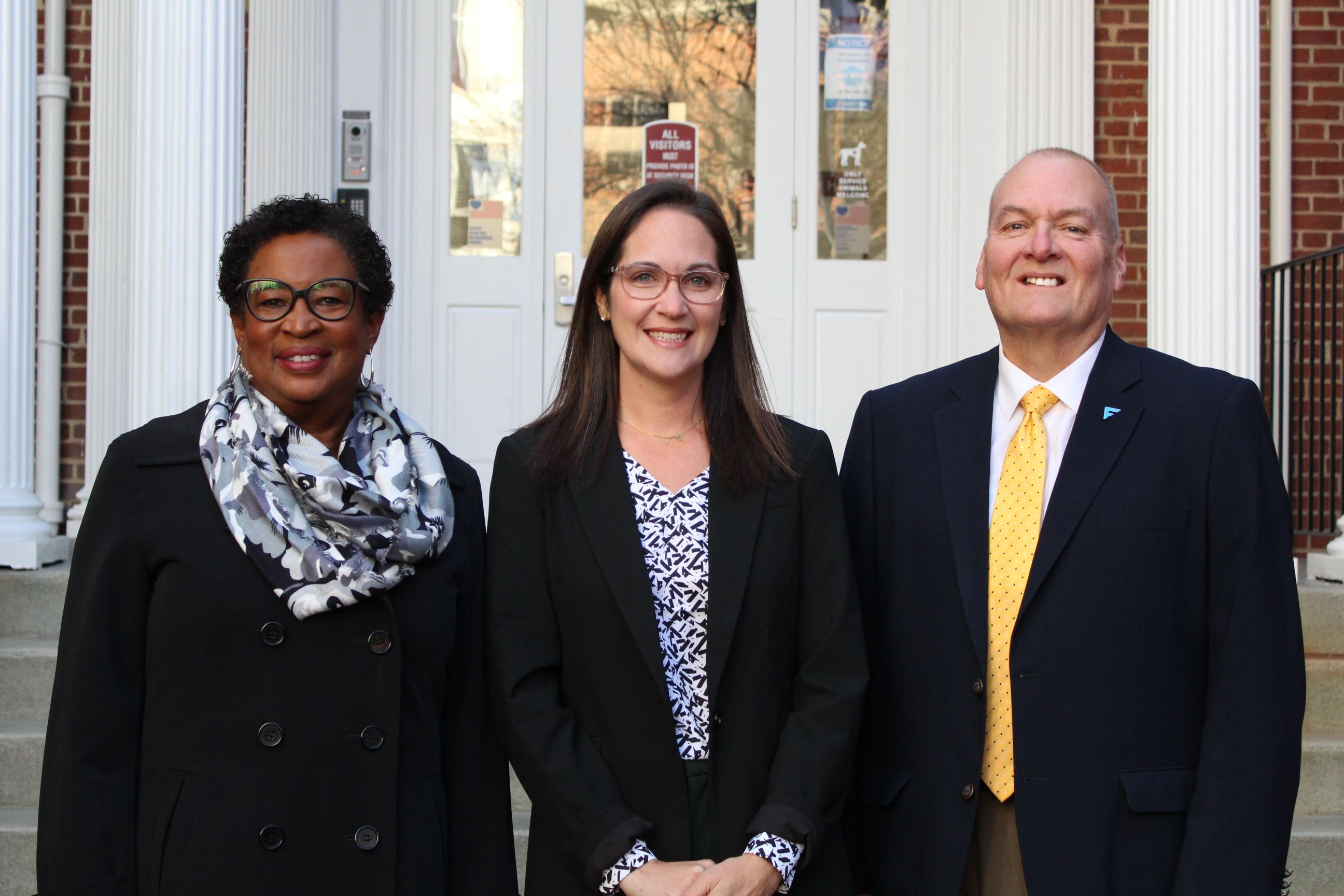 Two women and a man standing outside