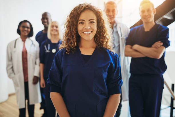 Group of healthcare professionals smiling and standing beside each other. 
