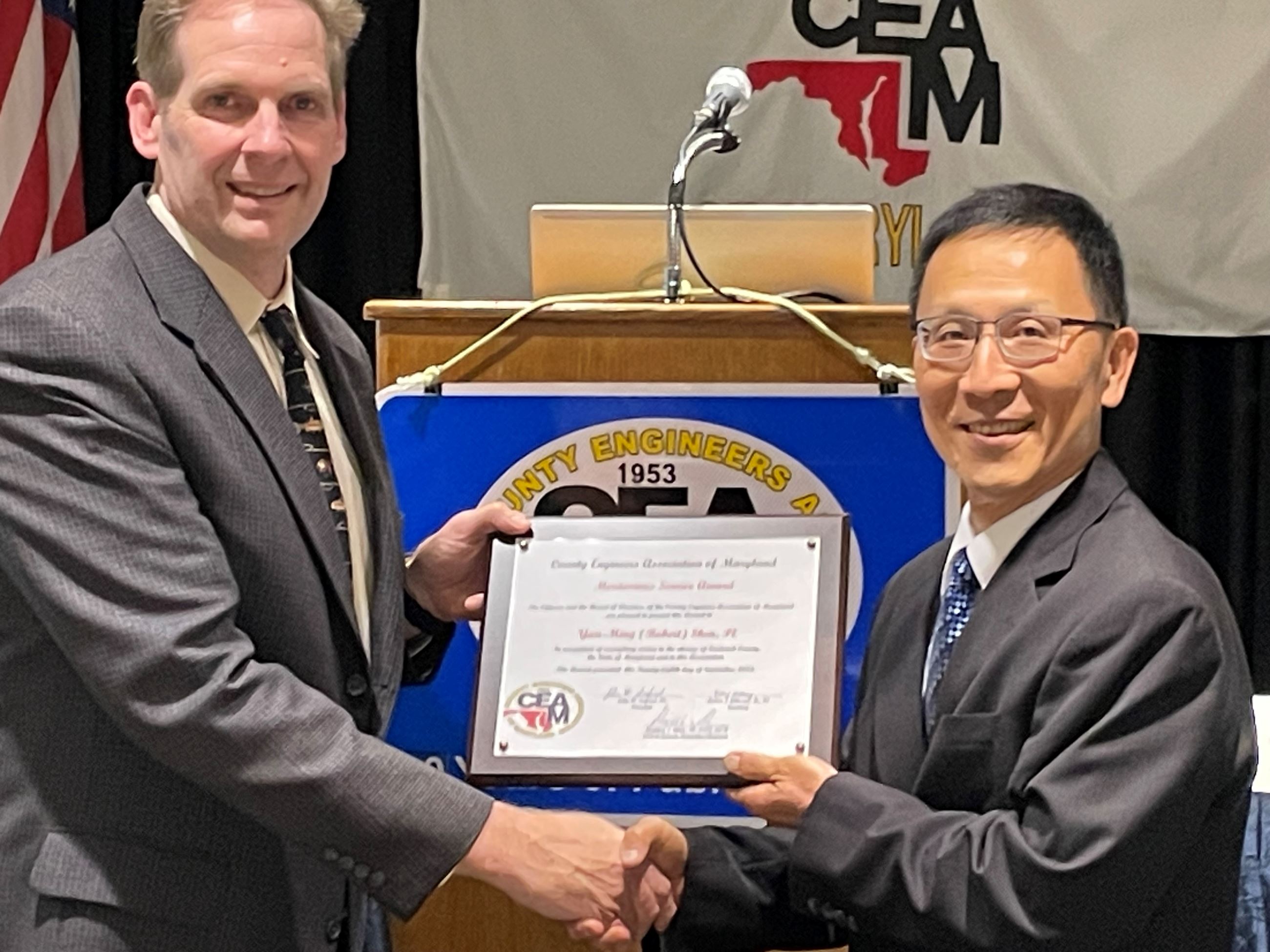 Two men holding an award