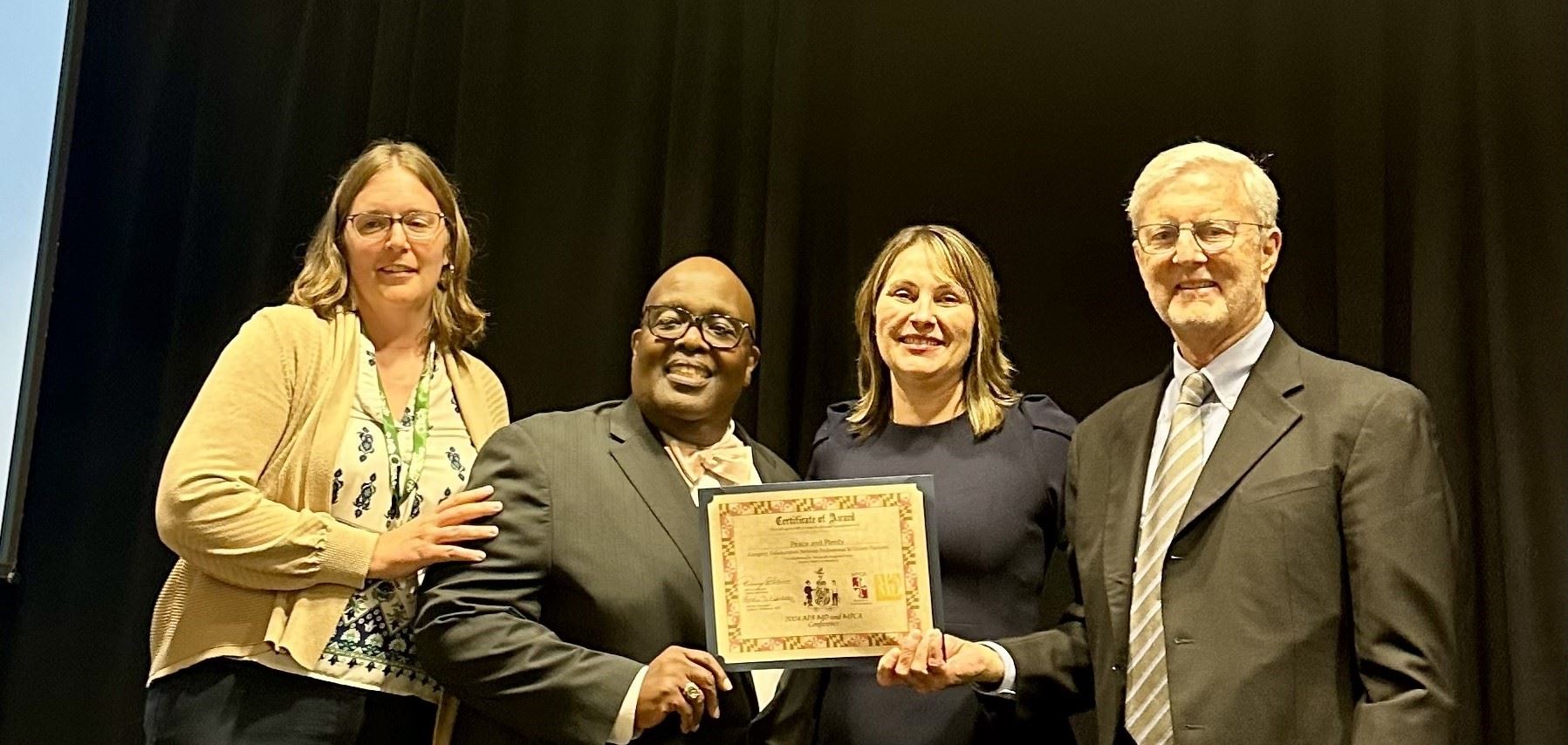 A group of people with an award posing for a photo.