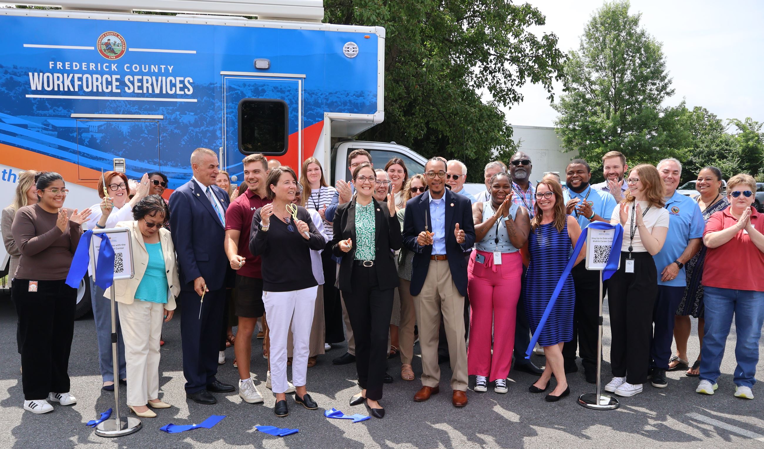 A group of people posing for a photo outside in front of the mobile career center.