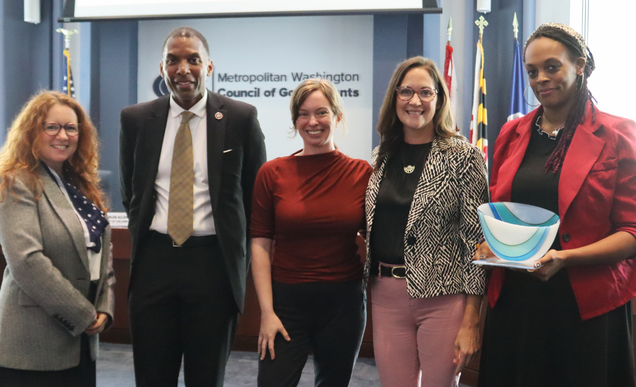 A group of people posing with an award.