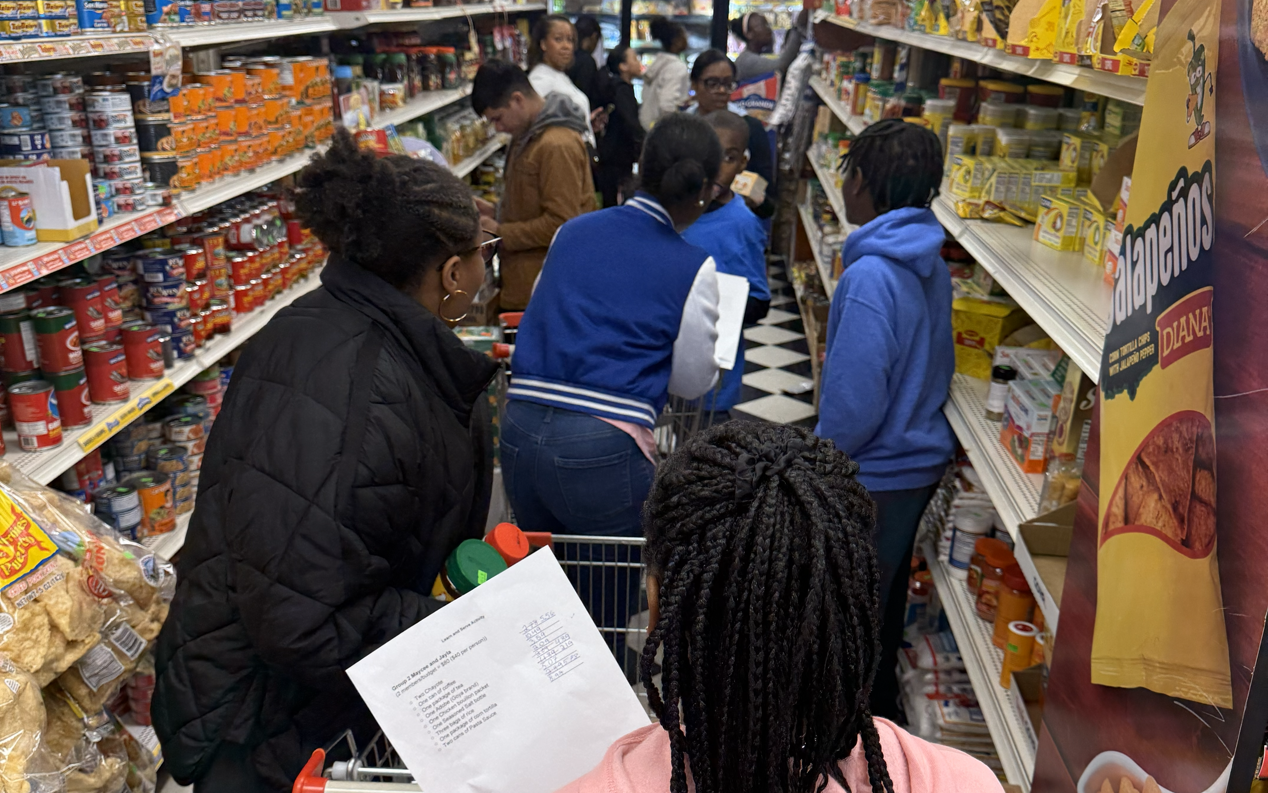 A group of people shopping in a grocery store.